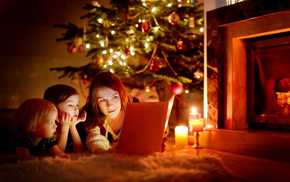 Mãe lendo livro para seus dois filhos